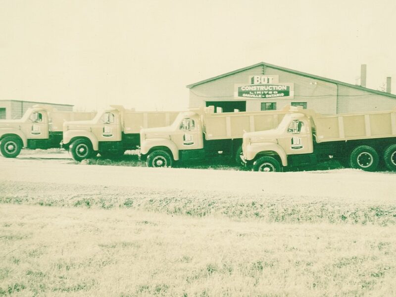 Facility - Photo of Original Main Shop with New Mack Dump Trucks